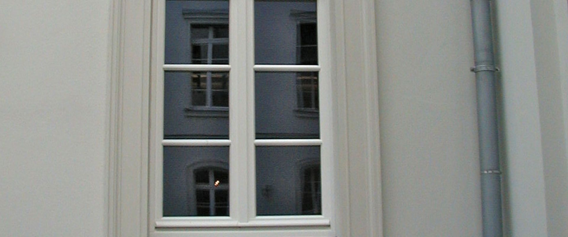 Denkmalpflegerische Fensterarbeit an einem Wohn- und Geschäftshaus.
